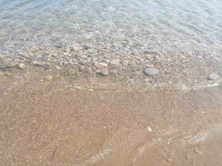 На берегу песок в море камни